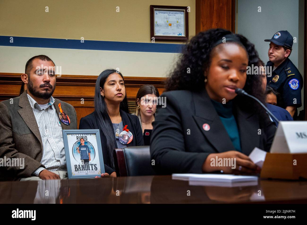 Un ufficiale di polizia del Campidoglio degli Stati Uniti, a destra, si appresta a entrare nella sala uditiva mentre Felix Rubio, a sinistra, e Kimberly Rubio, secondo da sinistra, la cui figlia Alexandria Rubio era uno dei bambini uccisi da un uomo da armi alla Robb Elementary School di Uvalde, Texas, ascoltano le osservazioni di Antonia Okafor, Direttore nazionale dell'Outreach delle Donne presso i proprietari di Gun d'America, secondo da destra, durante un'audizione della Camera Committee on Oversight and Reform "Evining the Practices and profits of Gun Manufacturers" nell'edificio Rayburn House Office di Washington, DC, 27 luglio 2022. Credit: Rod Lamkey/CNP/Sipa USA Foto Stock