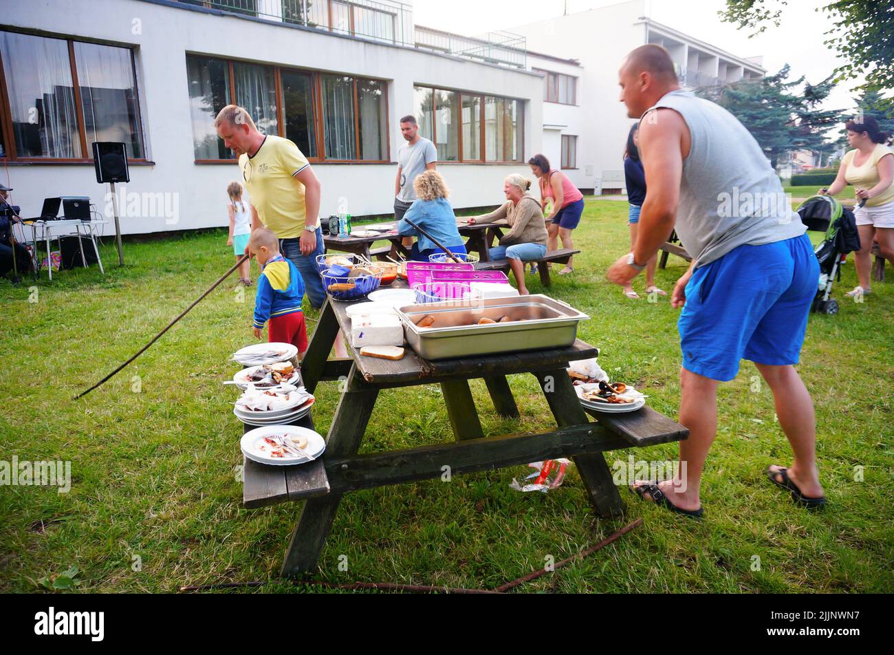 Le persone che si divertono durante un evento barbecue presso una località turistica al mare. Foto Stock