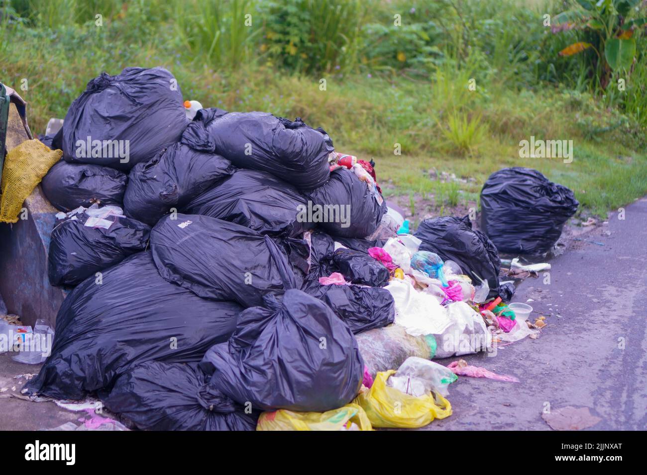 Un primo piano di rifiuti di plastica dump sul lato di una strada Foto Stock