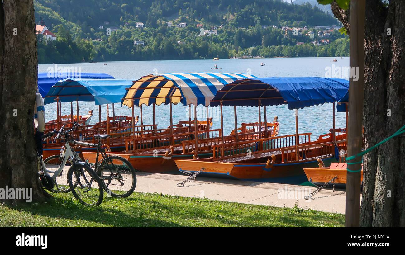 Una vista naturale di barche e biciclette sul lago di Bled in Slovenia durante una giornata di sole Foto Stock