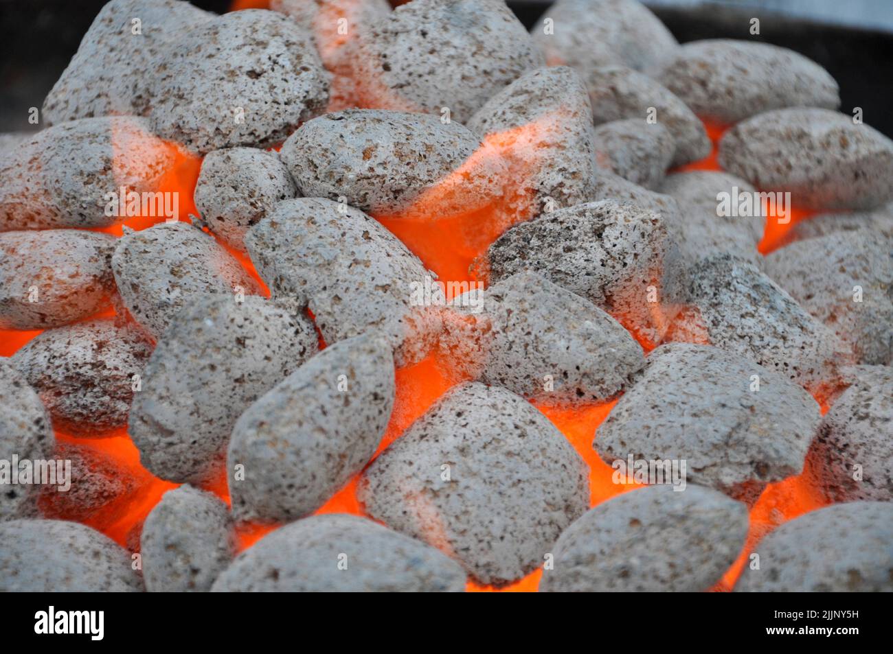 Un colpo di closeup di bricchette di carbone incandescente Foto Stock