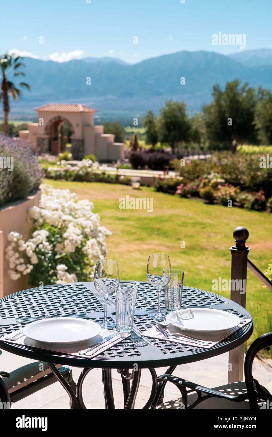 Uno scatto verticale di un tavolo servito in un bellissimo giardino in stile italiano Foto Stock