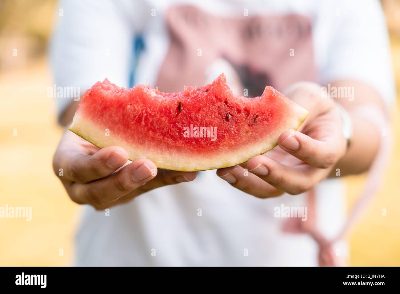 Il cocomero morso in mano in estate Foto Stock