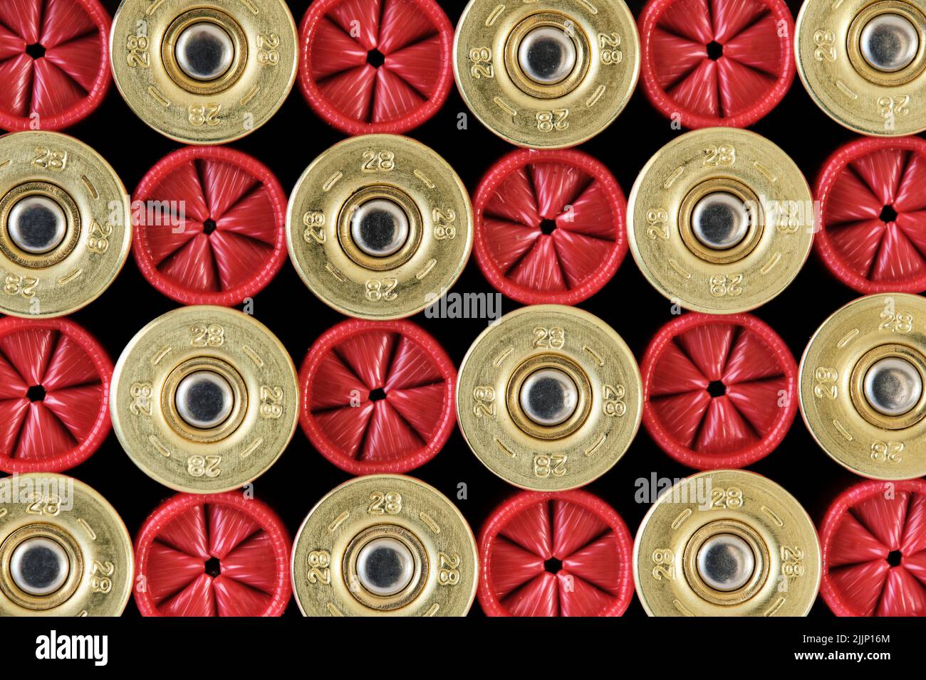 Vista dall'alto sfondo di gusci in plastica rossa per fucile di calibro 28 disposti insieme in file Foto Stock