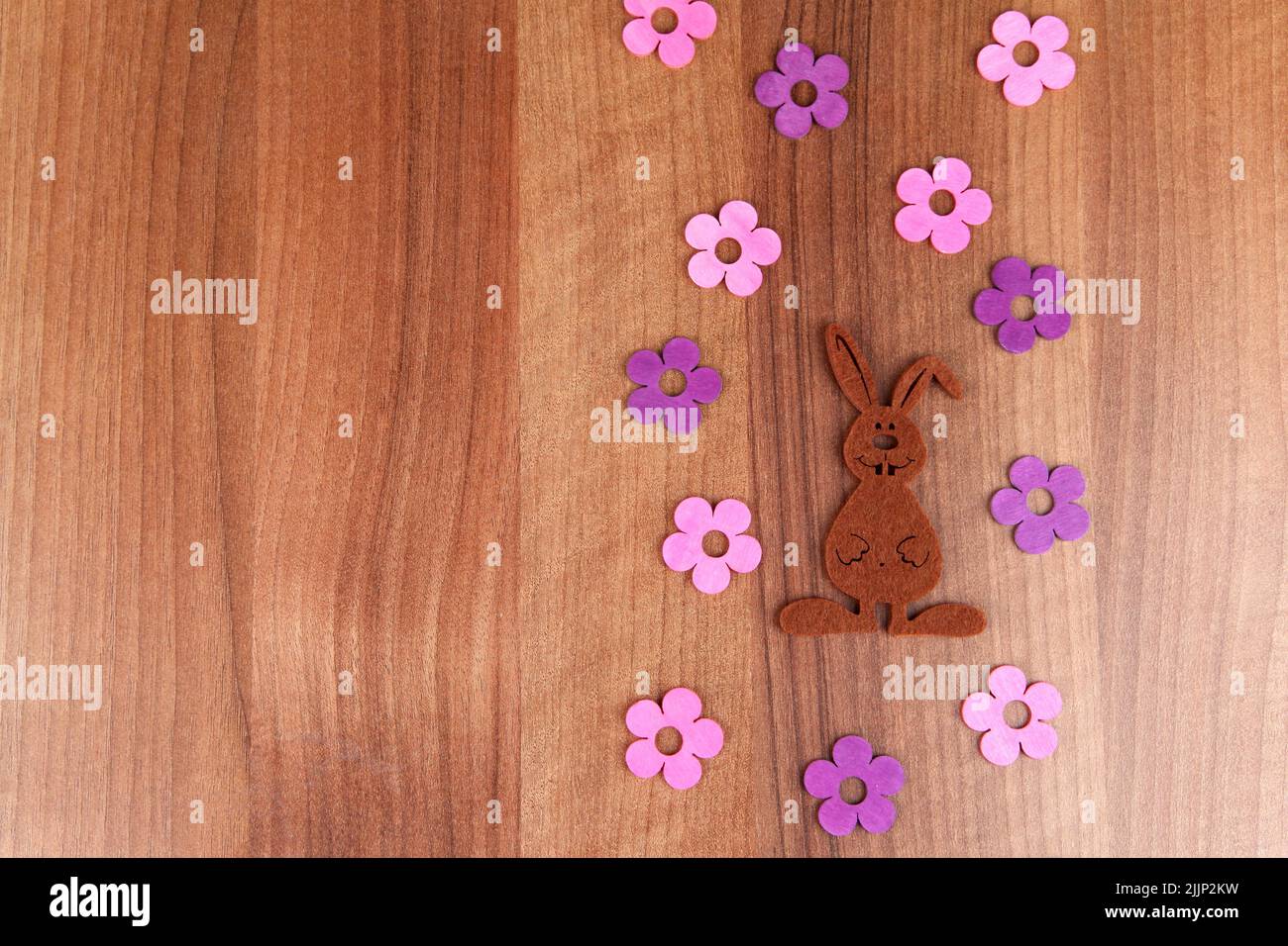 Un bel colpo di un coniglio di Pasqua fatto a mano con fiori lilla su un tavolo di legno Foto Stock