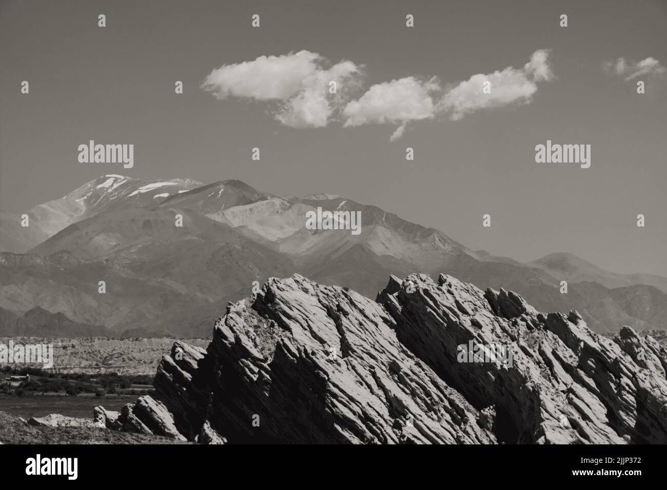 Una scala di grigi di colline con montagne nebbia sullo sfondo Foto Stock