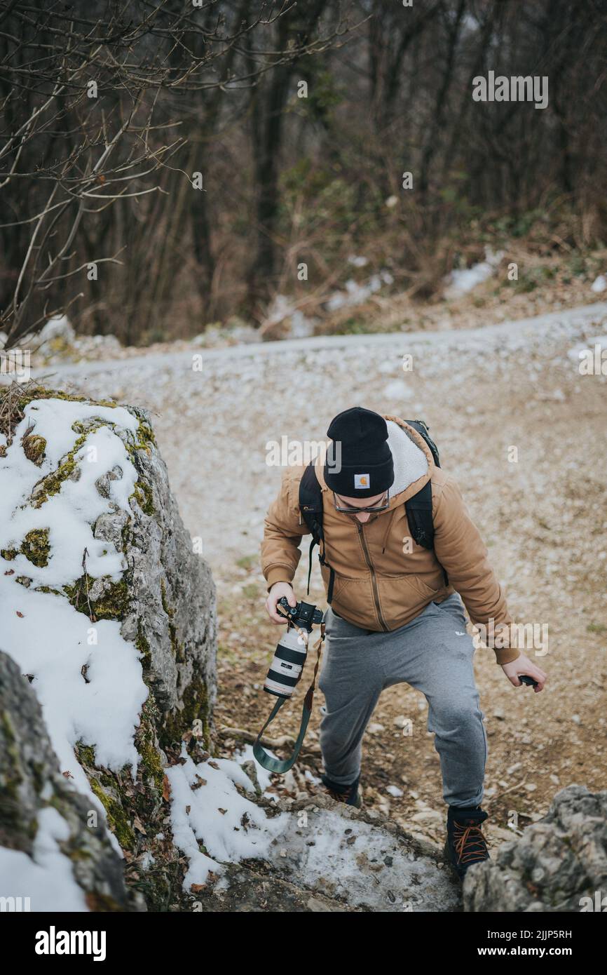 Un giovane turista con uno zaino e una macchina fotografica che cammina nella natura Foto Stock