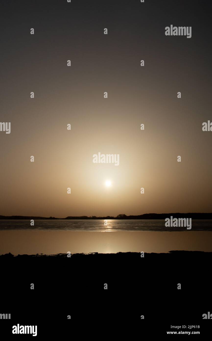 Una vista estetica del tramonto dalla spiaggia Foto Stock