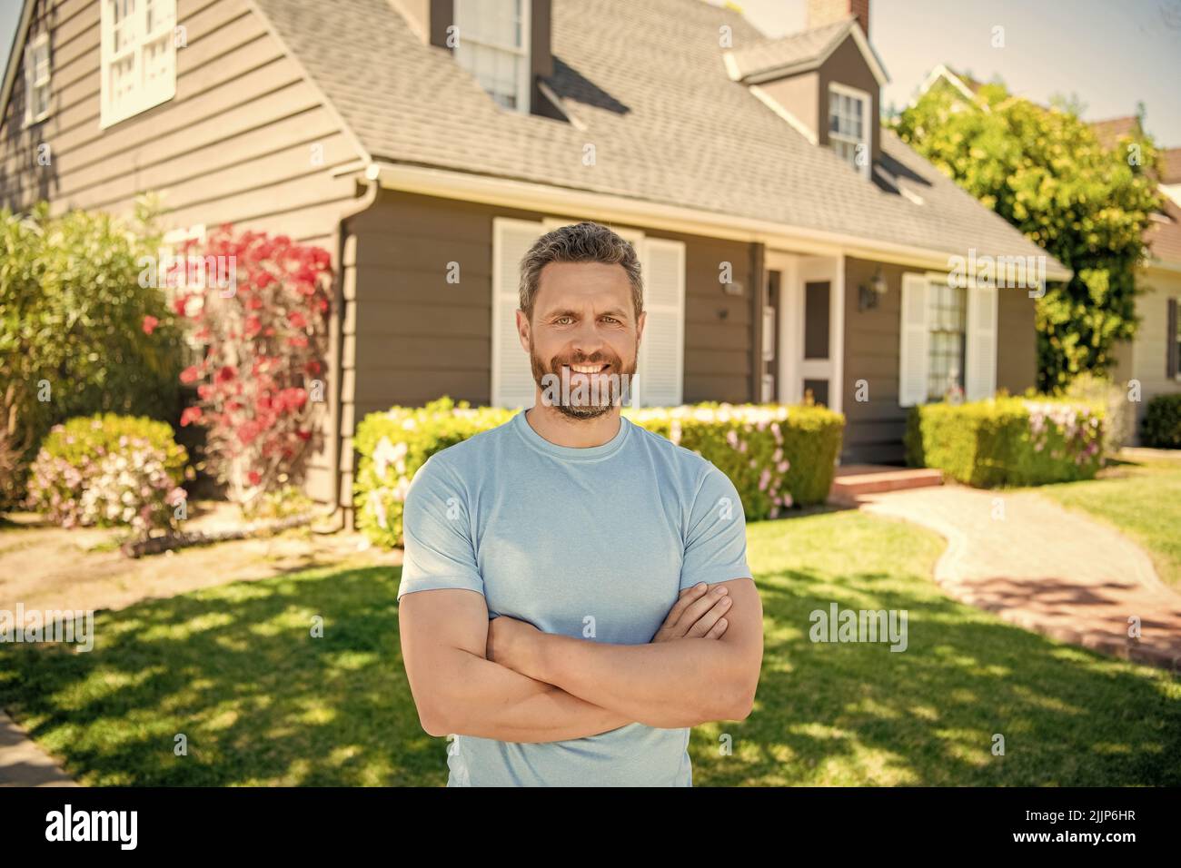 stupito unshaven ragazzo attraversato le mani vicino casa, realtor Foto Stock