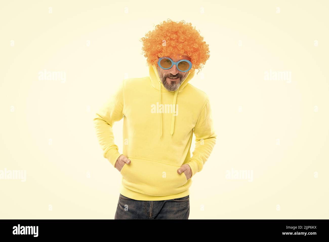 Strano uomo anziano indossare funky parrucca arancione con occhiali da sole partito in stile casual moda, bizzare Foto Stock