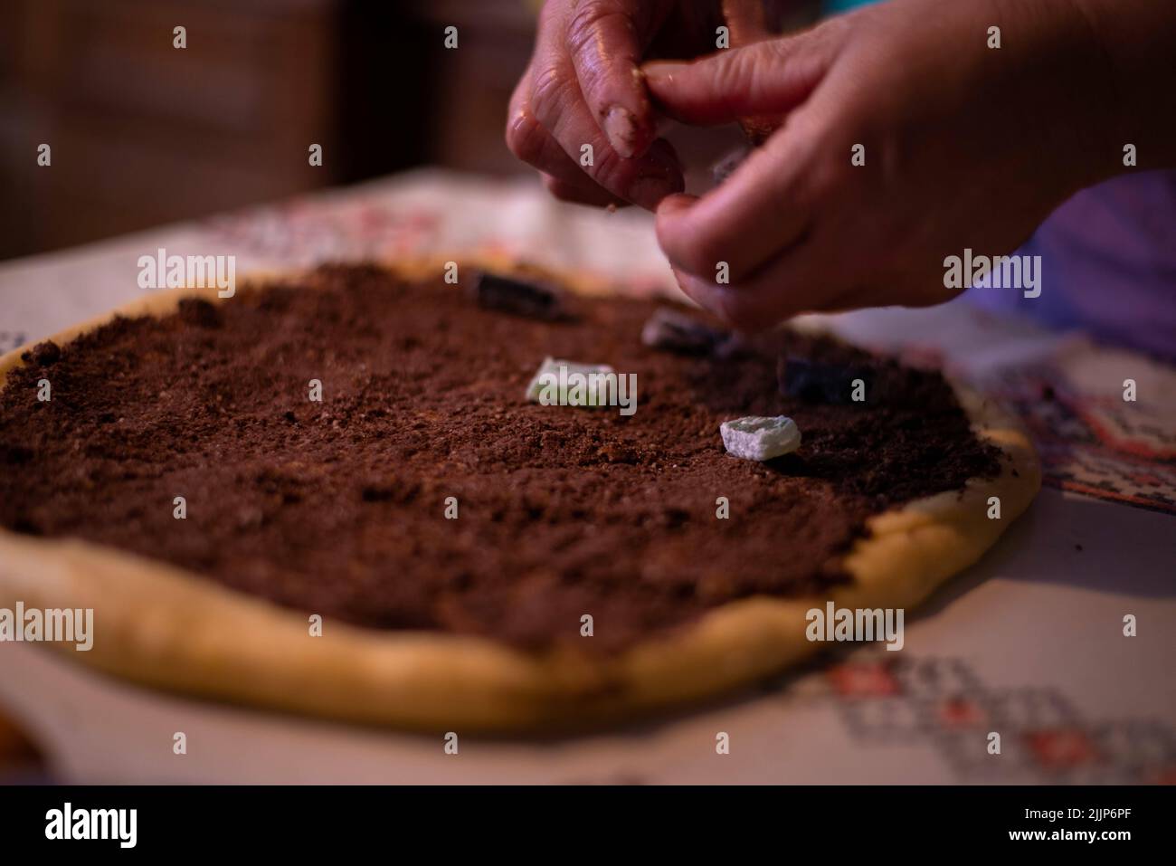 Una casalinga che aggiunge il ripieno all'impasto Foto Stock