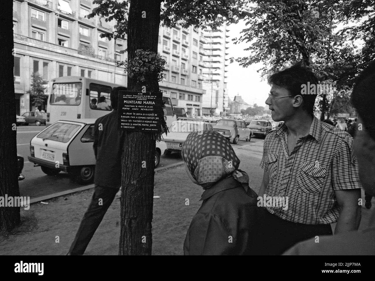 Bucarest, Romania, gennaio 1990. Passerby leggendo una lapide commemorativa per un colpo di mamma di 24 anni nel centro storico, una delle prime vittime della rivoluzione romena anticomunista del dicembre 1989. Foto Stock