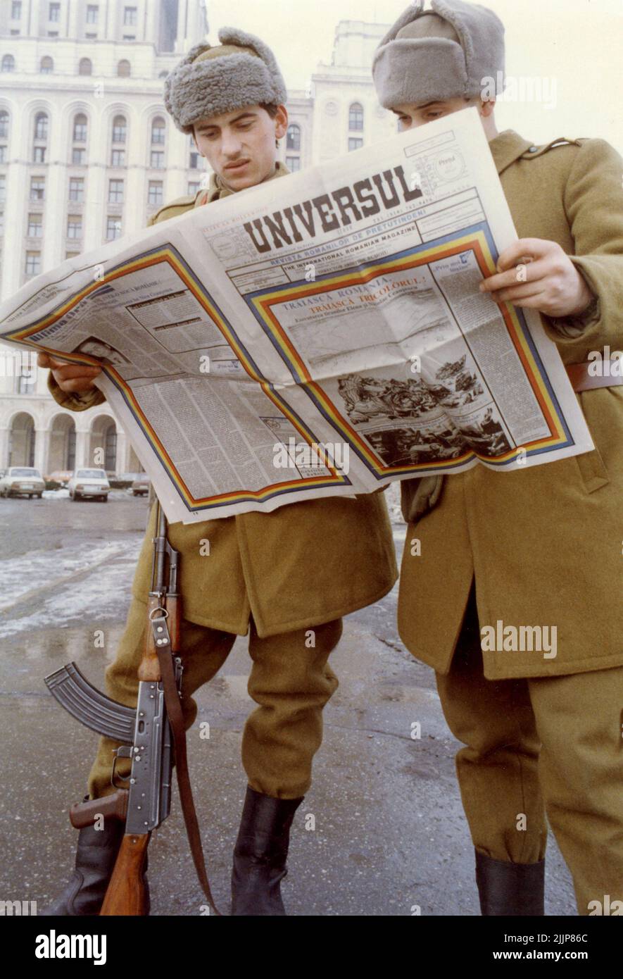 Bucarest, Romania, gennaio 1990. Giorni dopo la Rivoluzione Rumena, i soldati di fronte a 'Casa Scanteii/ Casa Presei Libere' si affacciavano sulla rivista 'Universull'. 'Universul' è stato pubblicato negli Stati Uniti da A. Buhoiu per i rumeni negli Stati Uniti c'è stata una sete di informazioni in Romania, soprattutto per quello proveniente da fuori del paese. Foto Stock
