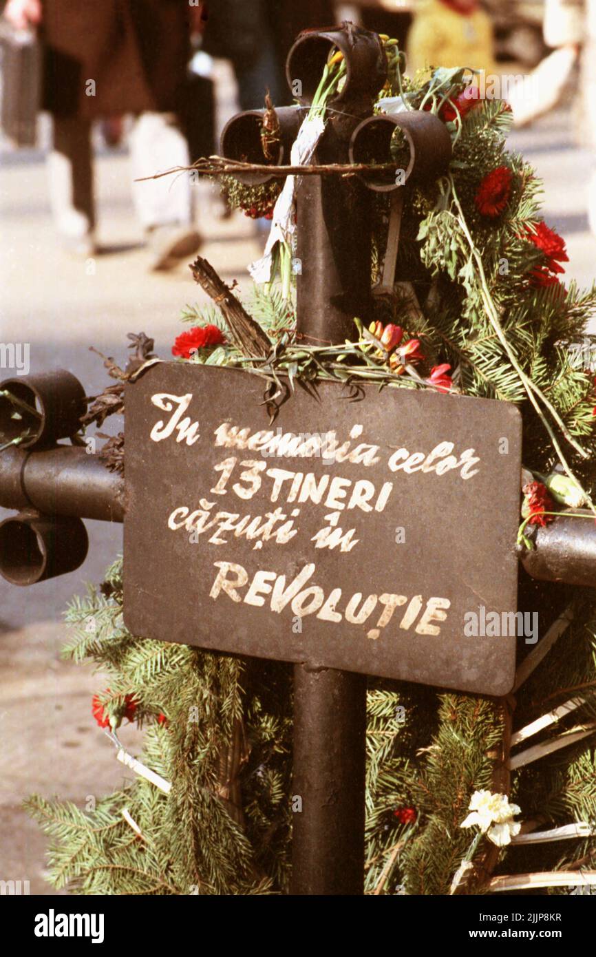 Bucarest, Romania, gennaio 1990. Attraversa il centro storico per le vittime della rivoluzione romena anticomunista del dicembre 1989. Il segno dice "in memoria dei 13 giovani caduti nella Rivoluzione". Il numero delle vittime è stato molto più elevato, ma la croce è stata posta nei tempi torbidi all'inizio del conflitto, quando non c'era abbastanza informazione sugli eventi. Foto Stock