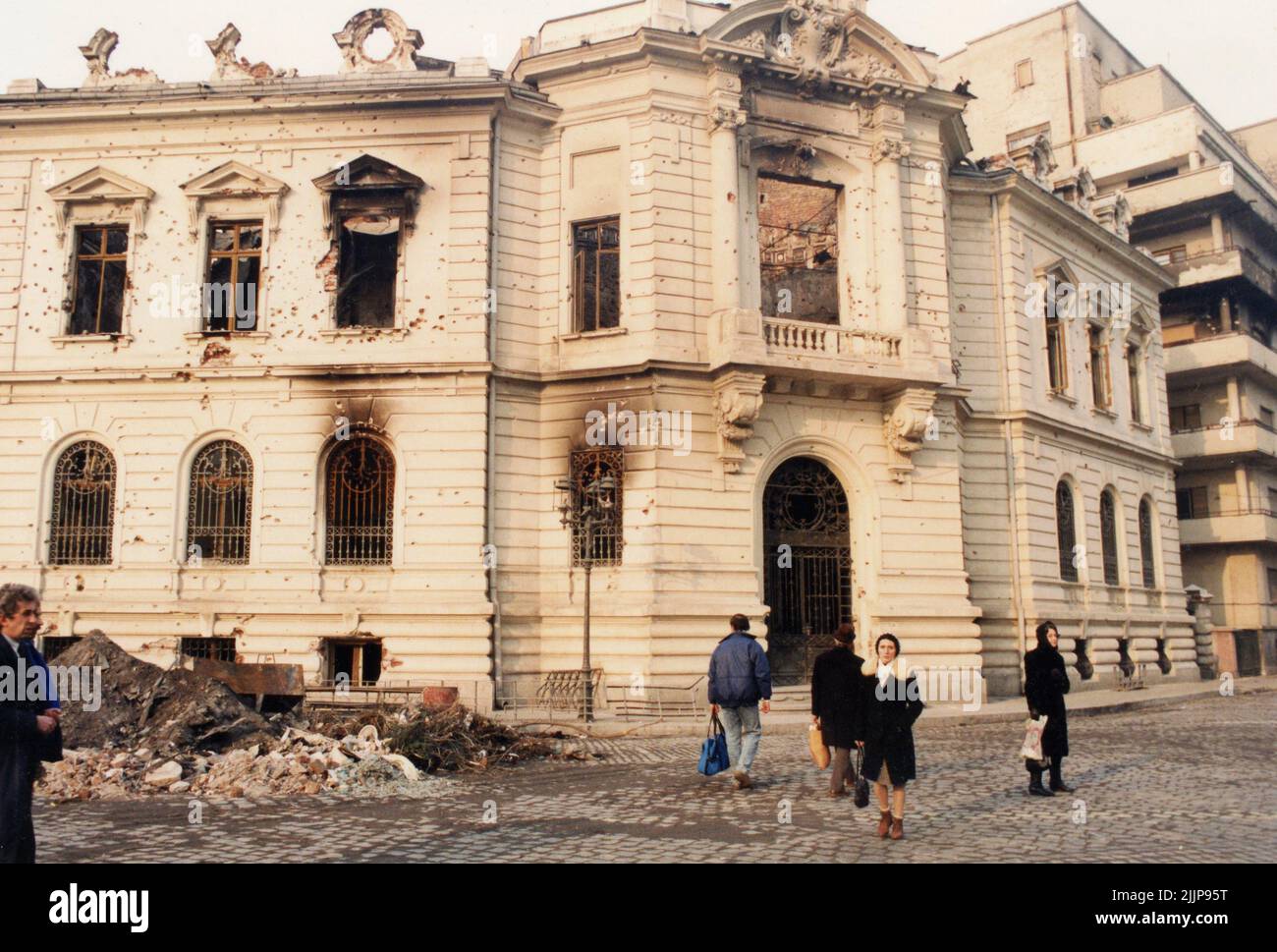 Bucarest, Romania, gennaio 1990. Edificio storico a Piata Palatului/ Piata Revolutiei distrutto dal fuoco durante la rivoluzione romena anticomunista del dicembre 1989. Foto Stock