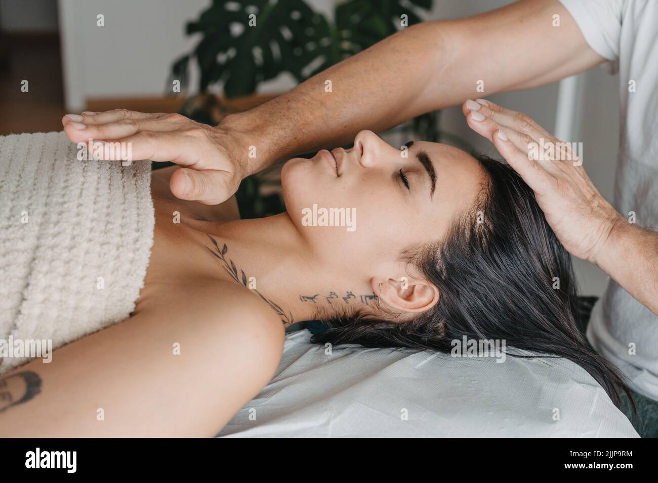 Profilo di una donna mentre riceve energia in una terapia Reiki Foto Stock