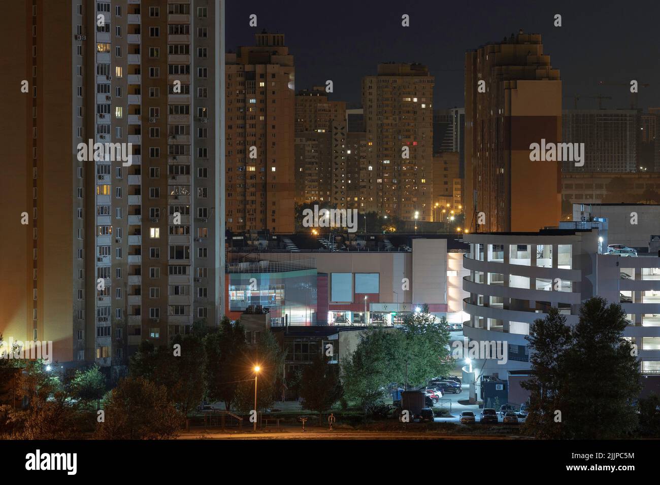 Paesaggio urbano notturno della grande città. Una luce brillante e multicolore sul coprifuoco sulle strade vuote. Edifici di appartamento in camera da letto comunità, penduter a. Foto Stock