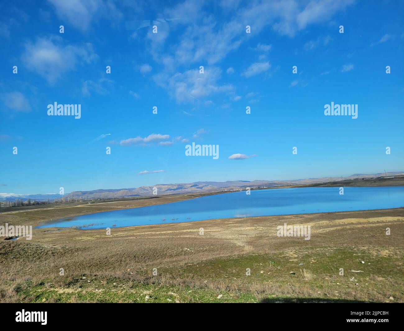 Un lago nel campo pianeggiante sullo sfondo di un paesaggio selvaggio. Foto Stock