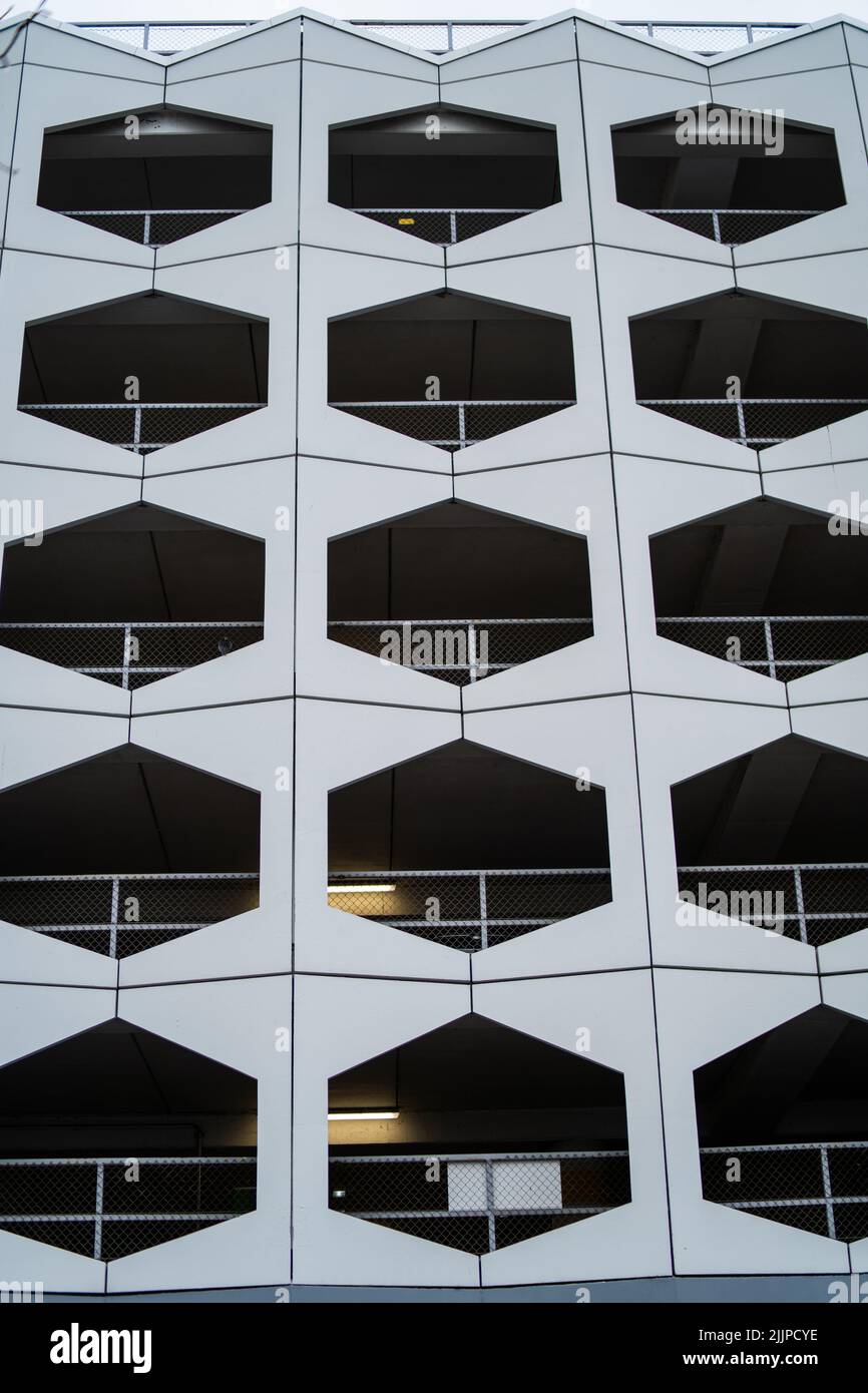 Un colpo verticale di un edificio bianco urbano con finestre geometriche nere a forma di motivo Foto Stock