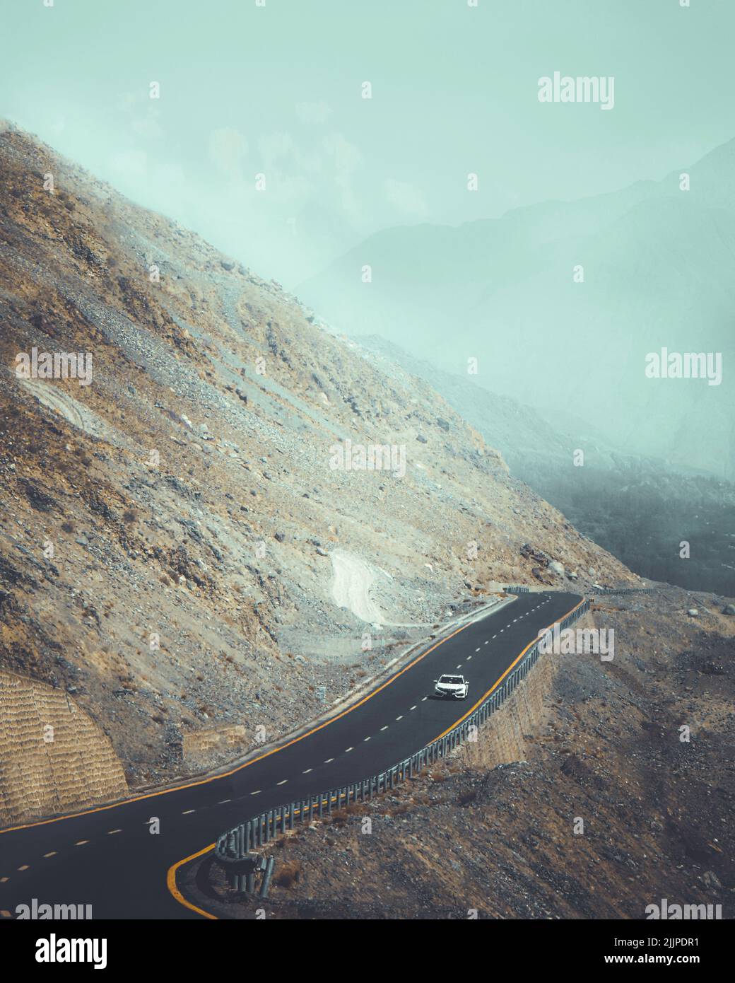 Un colpo verticale di un'auto sulla Karakoram Highway circondato da montagne in Pakistan Foto Stock