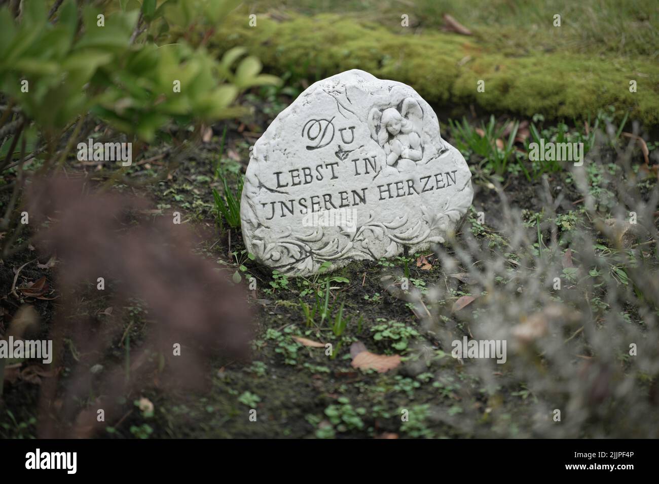 Una tomba con una pietra sulla quale è scritto in tedesco: Voi vivete nei nostri cuori Foto Stock