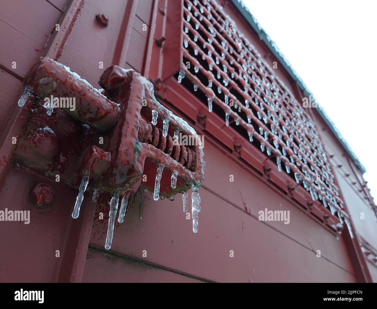 Un colpo a basso angolo di un carro rosso con le ghiacciate in inverno in Germania Foto Stock