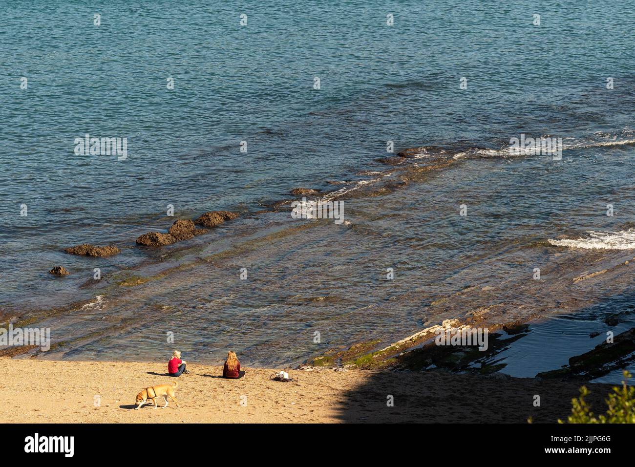 Una vista posteriore di due persone sulla spiaggia di Barrika in una giornata di sole in Spagna Foto Stock