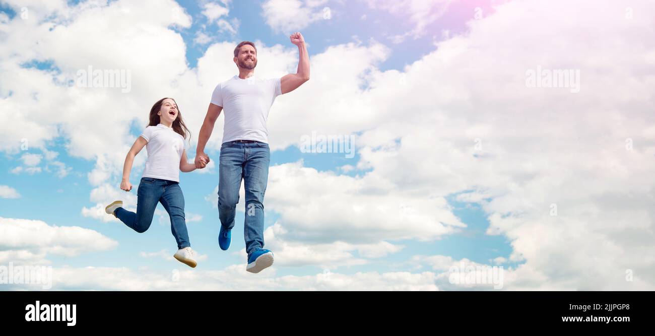 Padre e figlia saltano sul cielo, bandiera con spazio copia. Felice padre e figlia saltano nel cielo. Felice infanzia Foto Stock