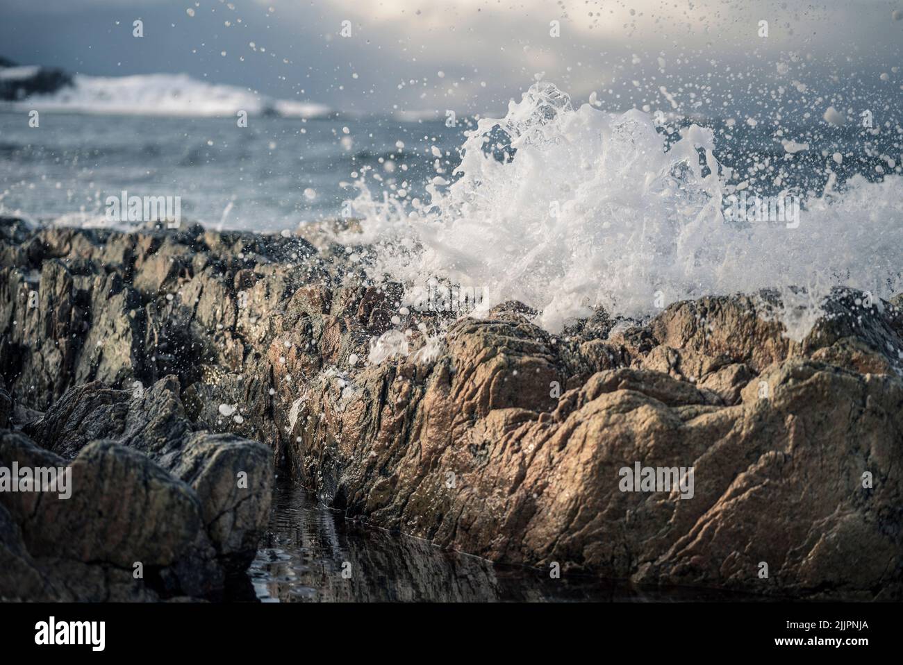 Un primo colpo di onde di mare tempestose che si infrangono sulla riva con schiuma di mare Foto Stock