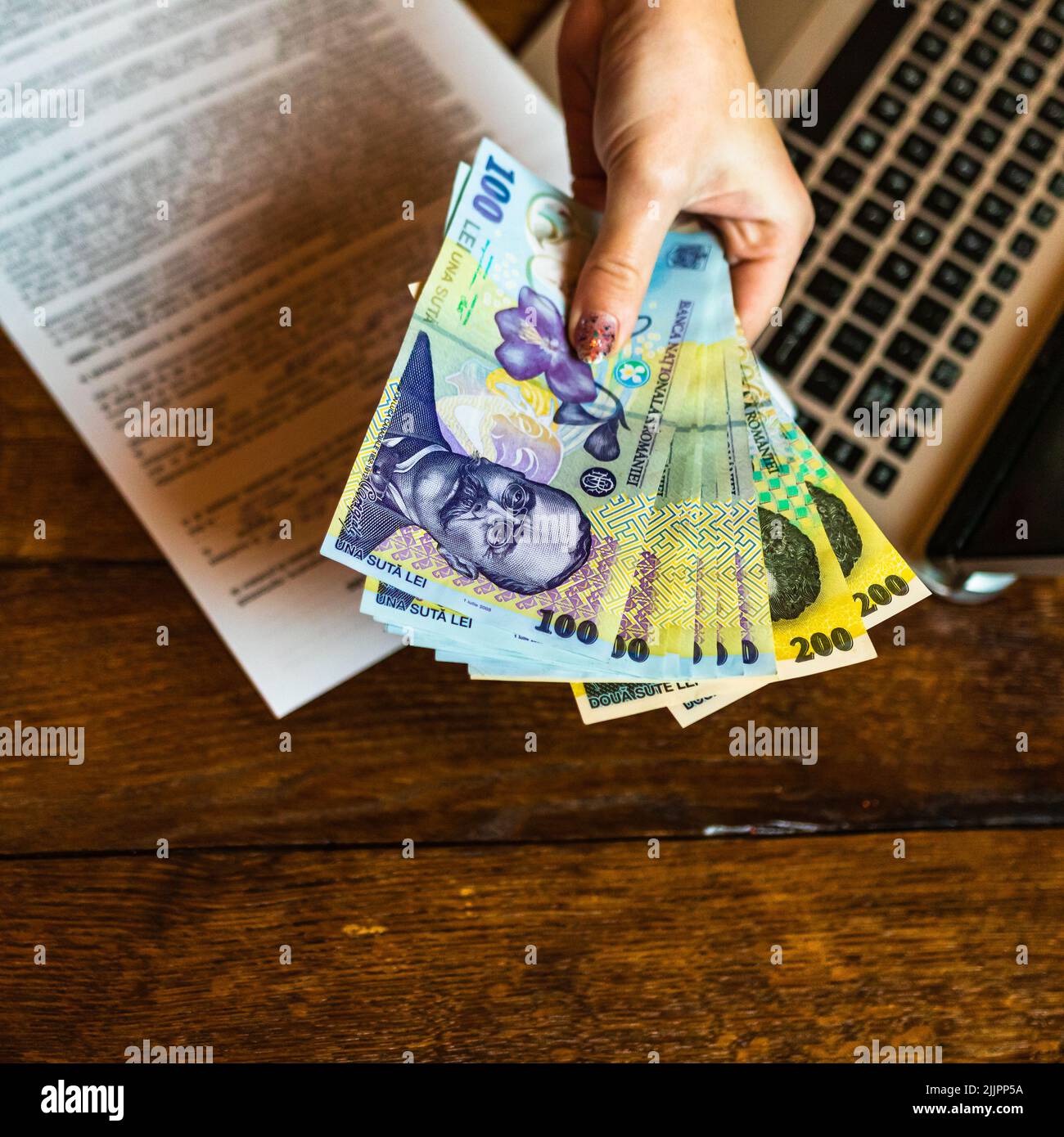 Un primo piano di un contratto e denaro su una mano mans Foto Stock