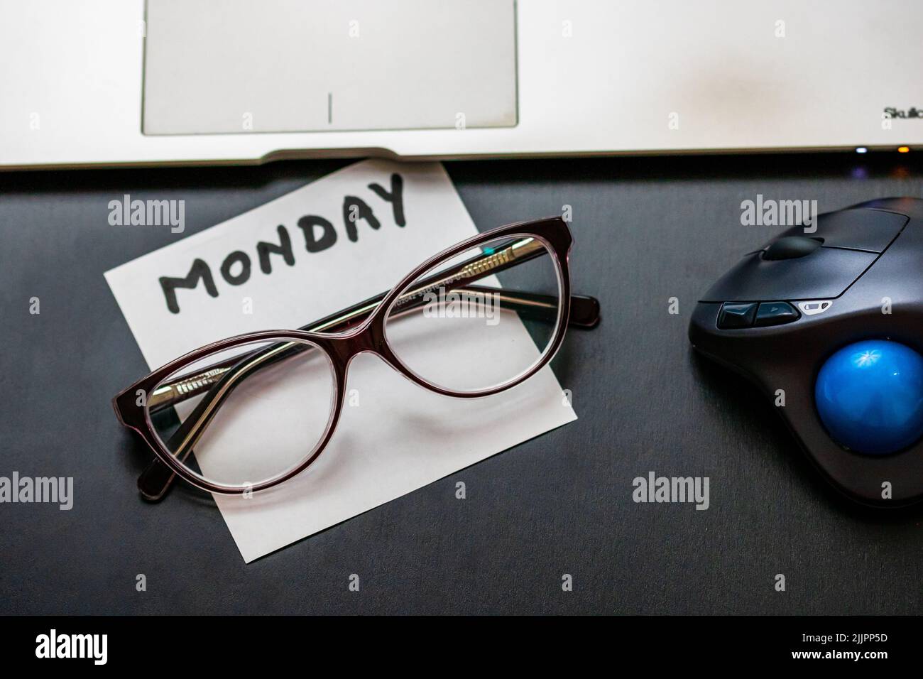 Gli occhiali, la nota, il mouse e il computer portatile su un tavolo in ufficio Foto Stock