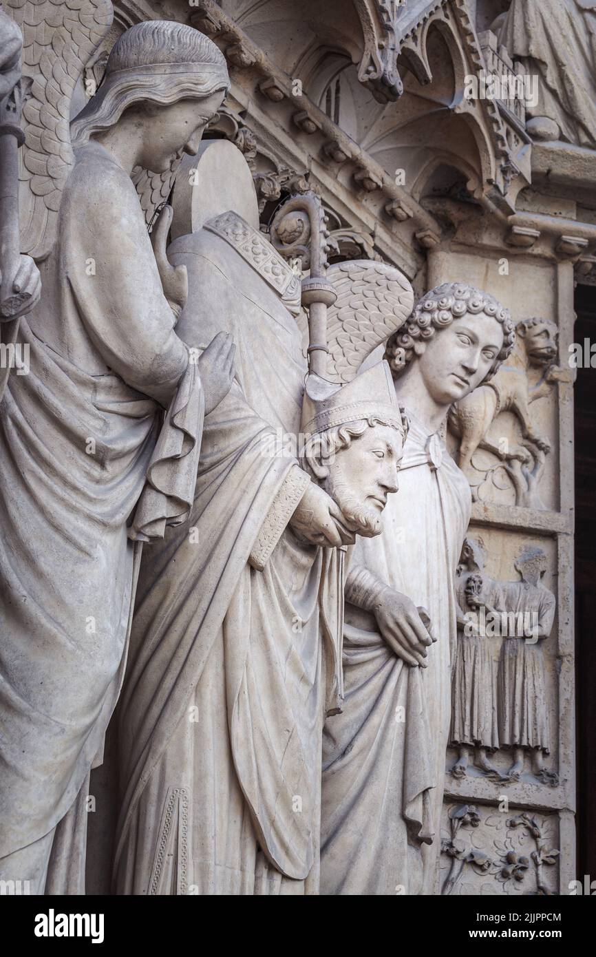 Saint Denis senza testa e angelo, Notre dame dettaglio facciata a Parigi, Francia Foto Stock