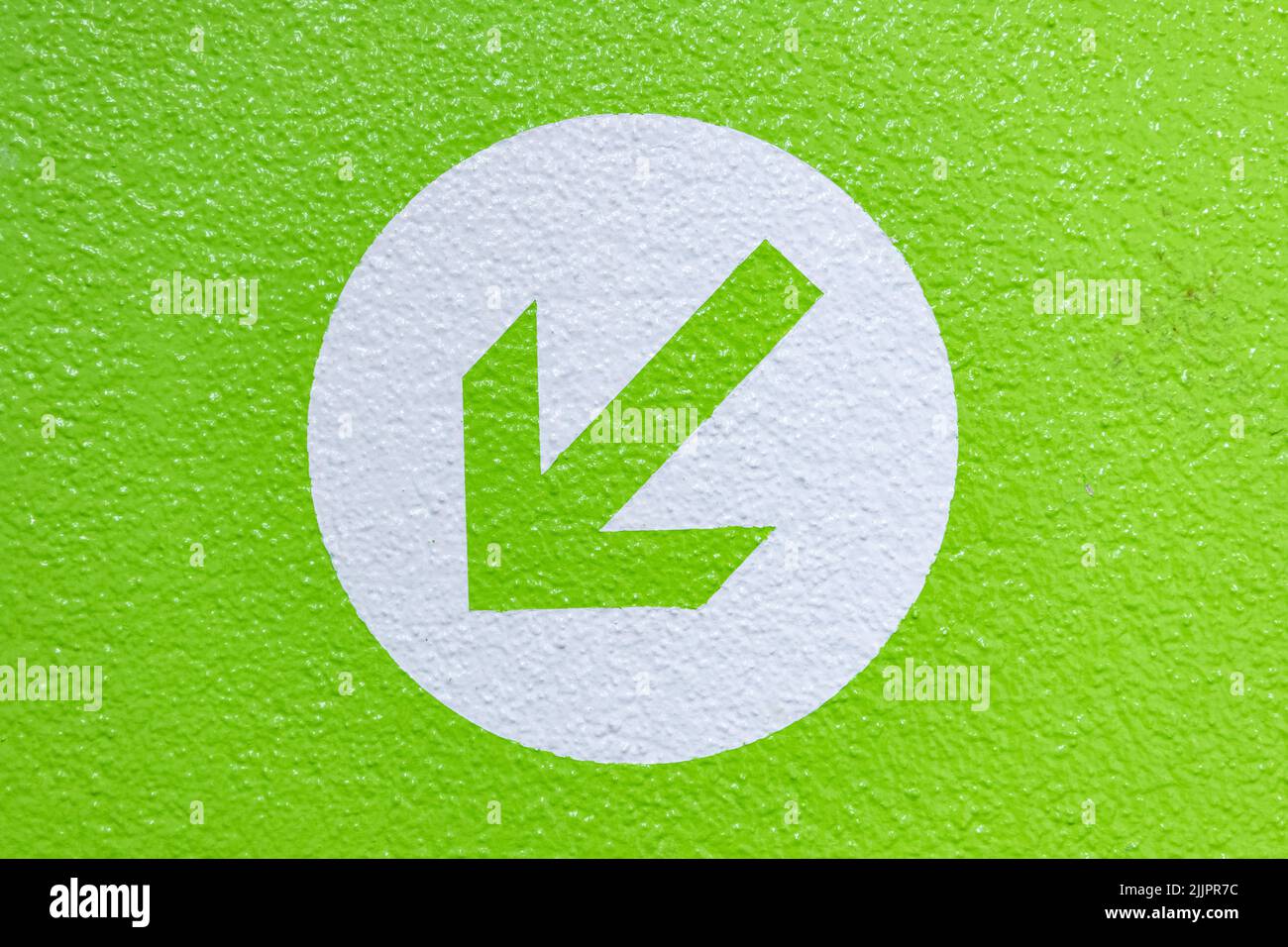 Primo piano di una freccia dipinta sullo sfondo verde Foto Stock