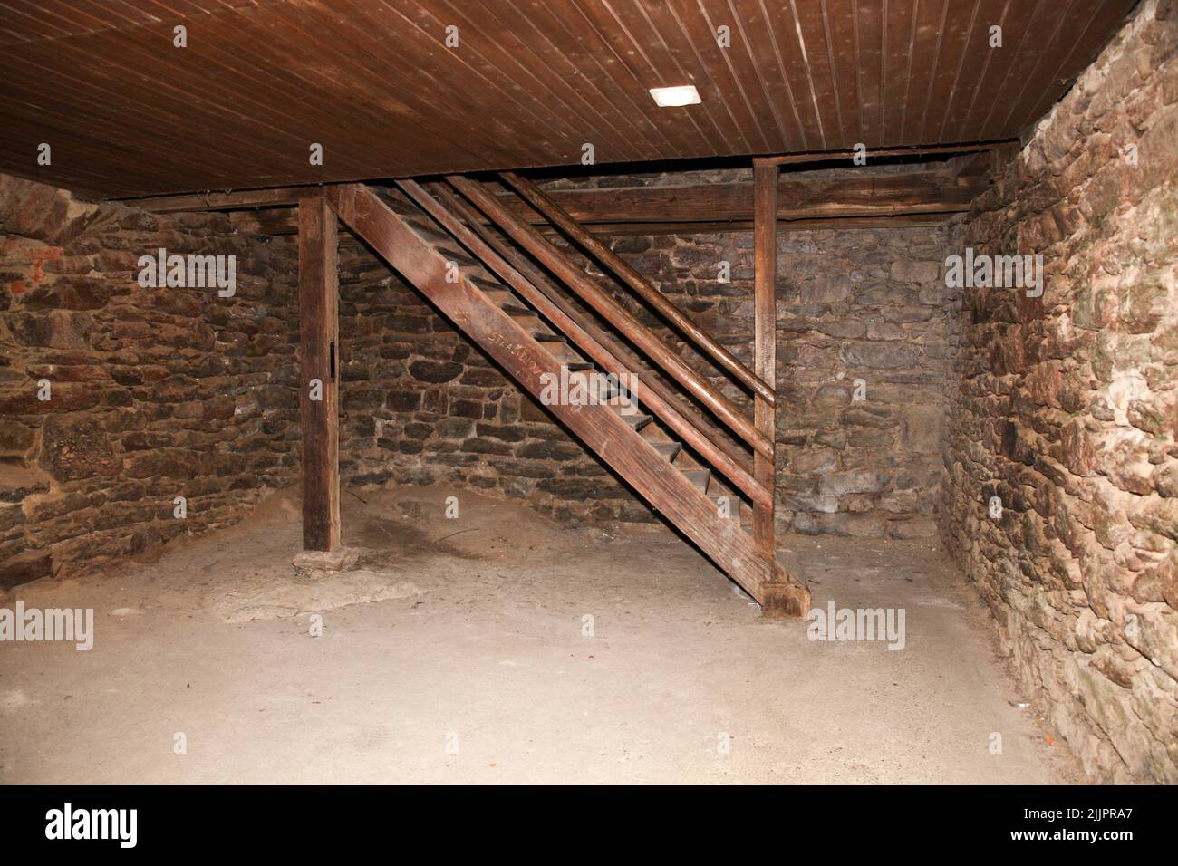 I gradini in legno all'interno di un edificio vuoto con pareti in pietra Foto Stock