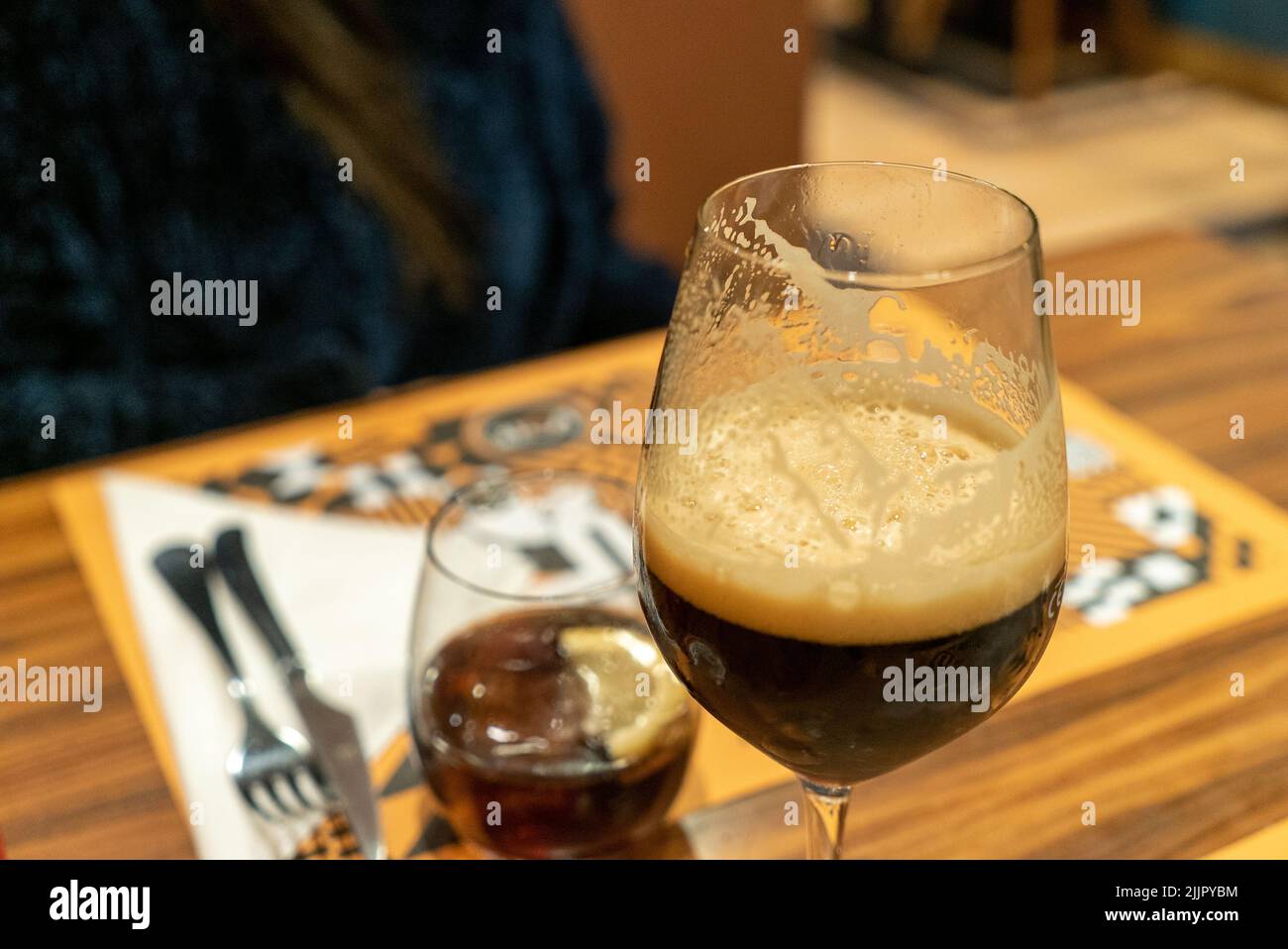Un focus shot selettivo di un bicchiere di birra nera su un tavolo al coperto, Lisbona, Portogallo Foto Stock