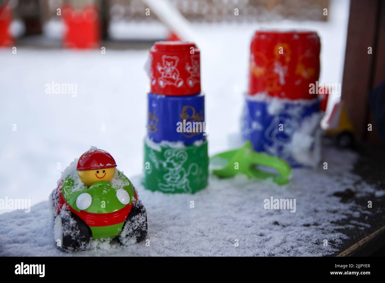 Un primo piano di giocattoli colorati per bambini sul balcone innevato Foto Stock