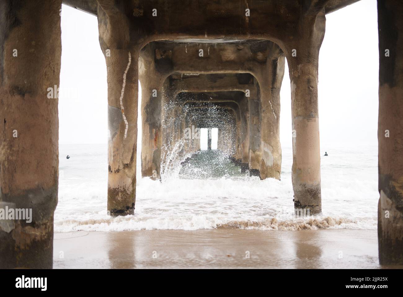 Una bella vista delle onde che colpiscono la riva sotto il molo Foto Stock