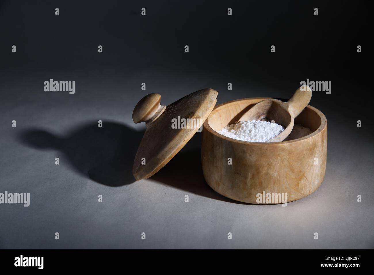 Un contenitore di legno e scooper con farina presa in studio Foto Stock