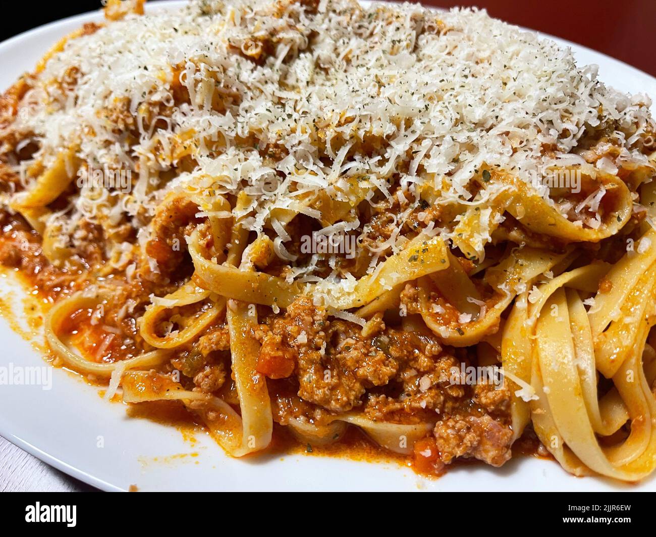 Un primo piano di deliziosa pasta fatta in casa ragu con parmigiano in cima Foto Stock