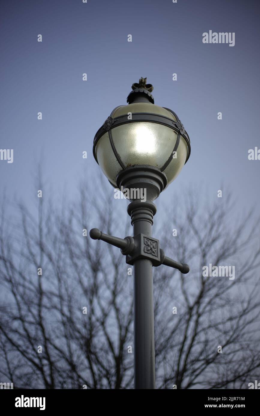 Un lampione di luci di strada su una strada contro un cielo blu a Londra Foto Stock