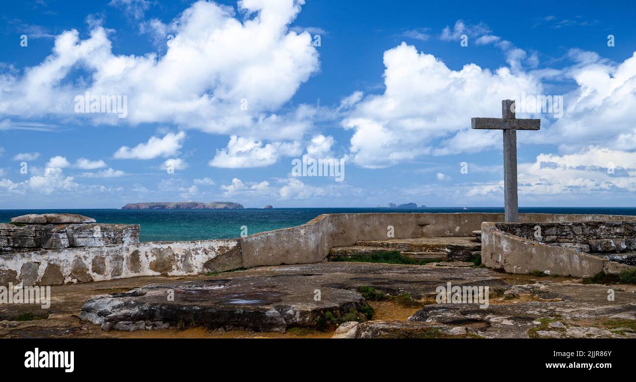 Attraversa la costa dell'Oceano Atlantico a Cruz dos Remedios, Peniche Peninsula, Portogallo. Stagcape sotto le nuvole soffici in un cielo blu Foto Stock