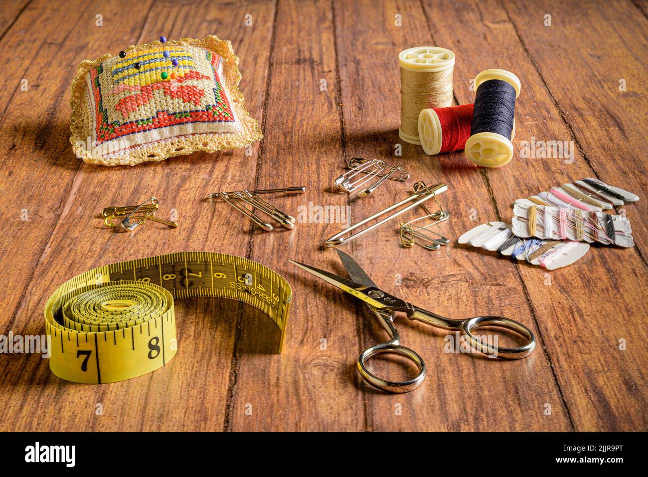 Un set di accessori da cucire su sfondo di legno Foto Stock