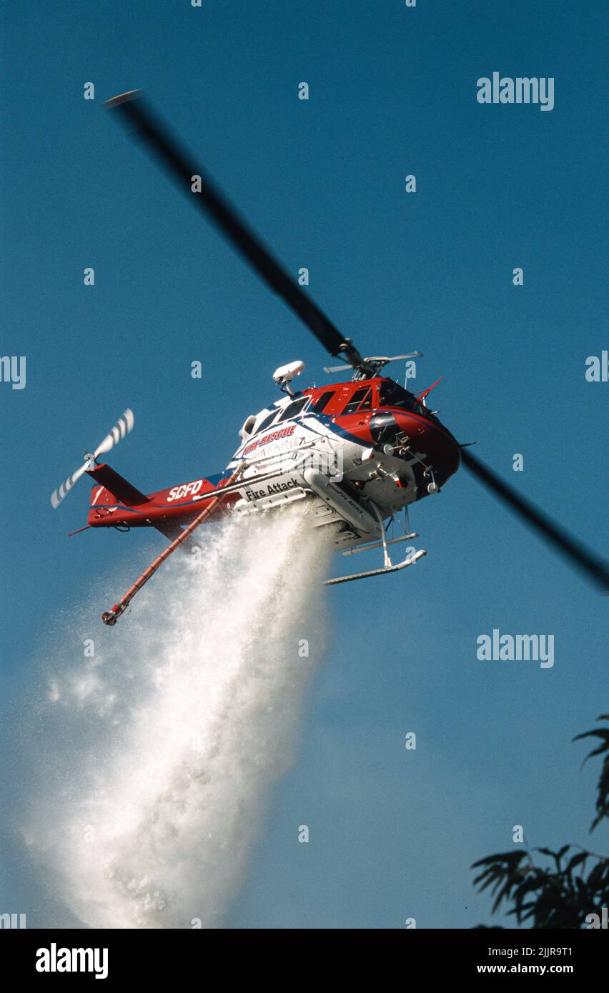 San Diego Fire-Rescue Copter 1 facendo una goccia d'acqua su un fuoco di terra selvatica (pennello) a San Diego, California Foto Stock