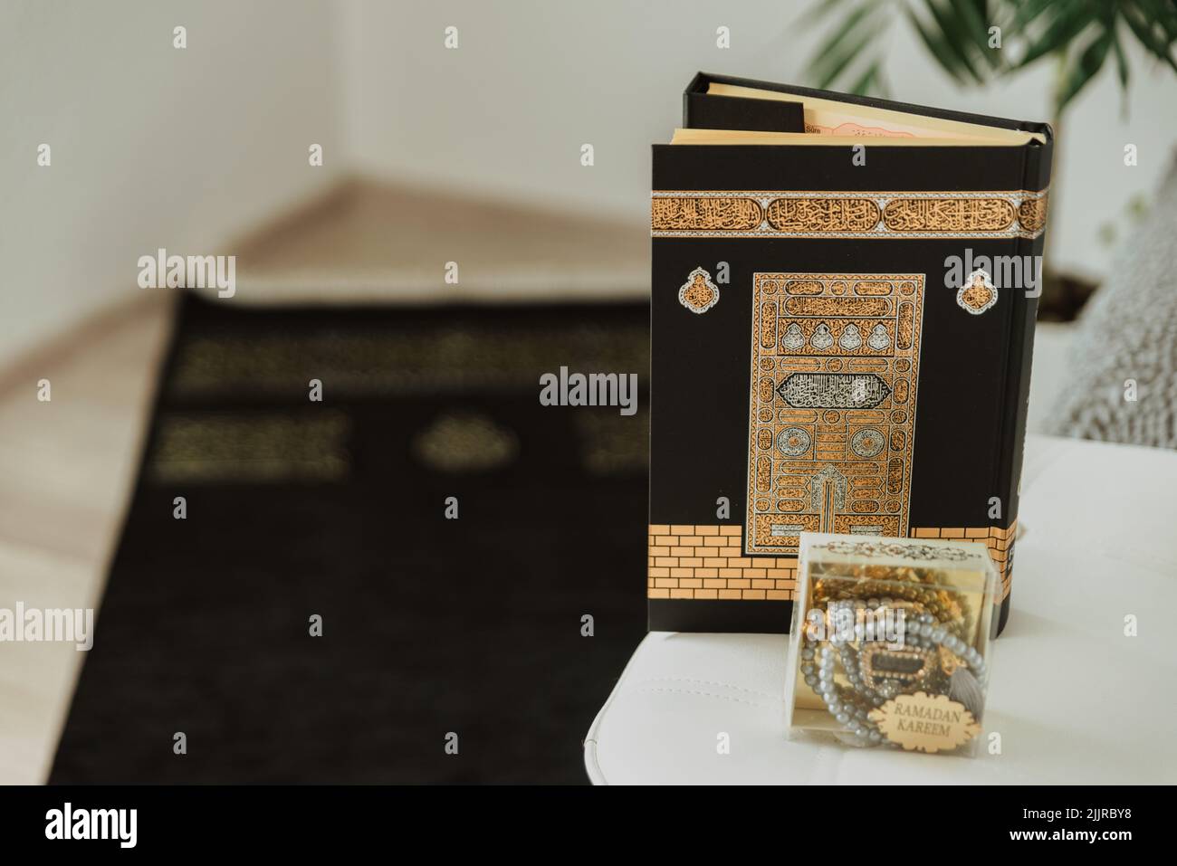 La preghiera set-tappeto nero e velluto nero Quran, decorato con modello Kaaba, e rosario fatto di perle con l'iscrizione Ramadan Kareem Foto Stock