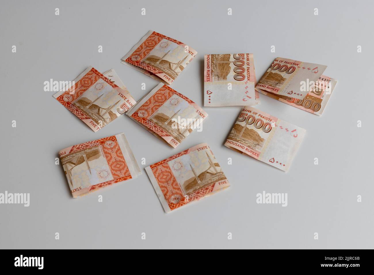 Cinquemila banconote ripiegate su sfondo bianco Foto Stock