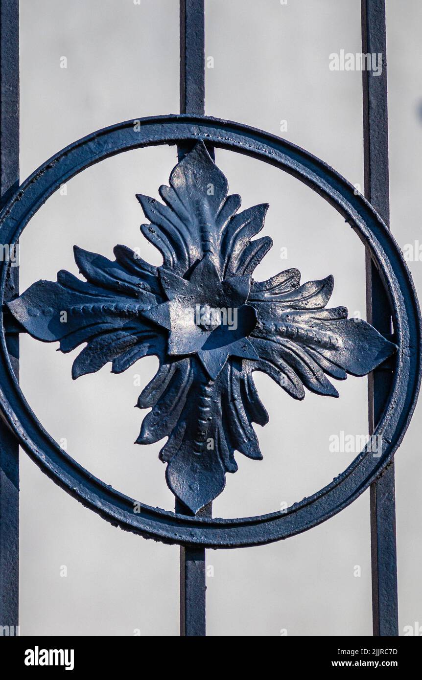 Un motivo di metallo blu nella forma di un fiore su una parete Foto Stock