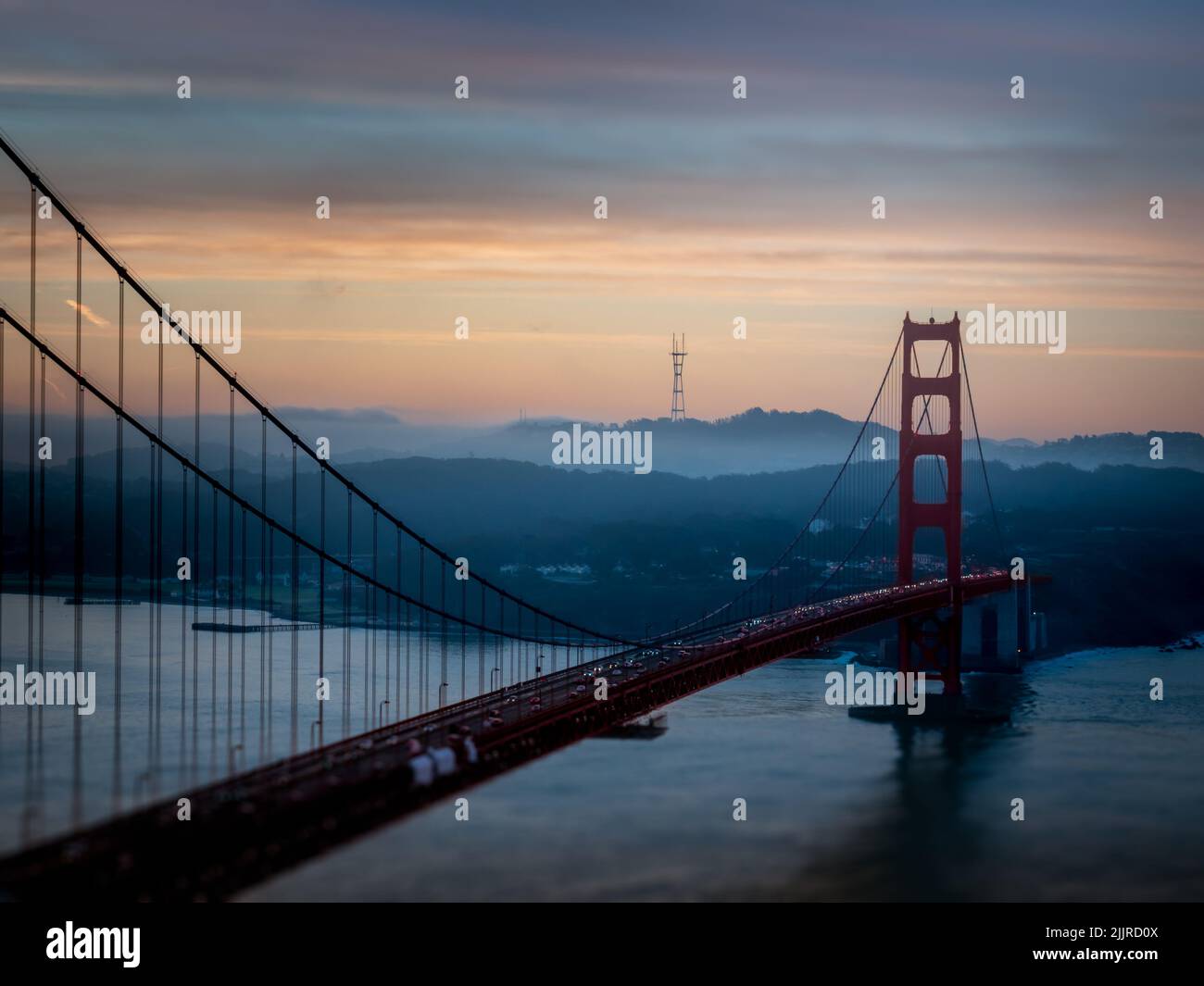 Il Golden Gate Bridge e la baia con le montagne sullo sfondo al tramonto Foto Stock