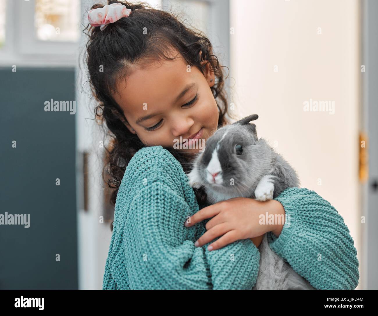 Ciao Rabbit, una bambina adorabile che si lega al suo coniglio in casa. Foto Stock