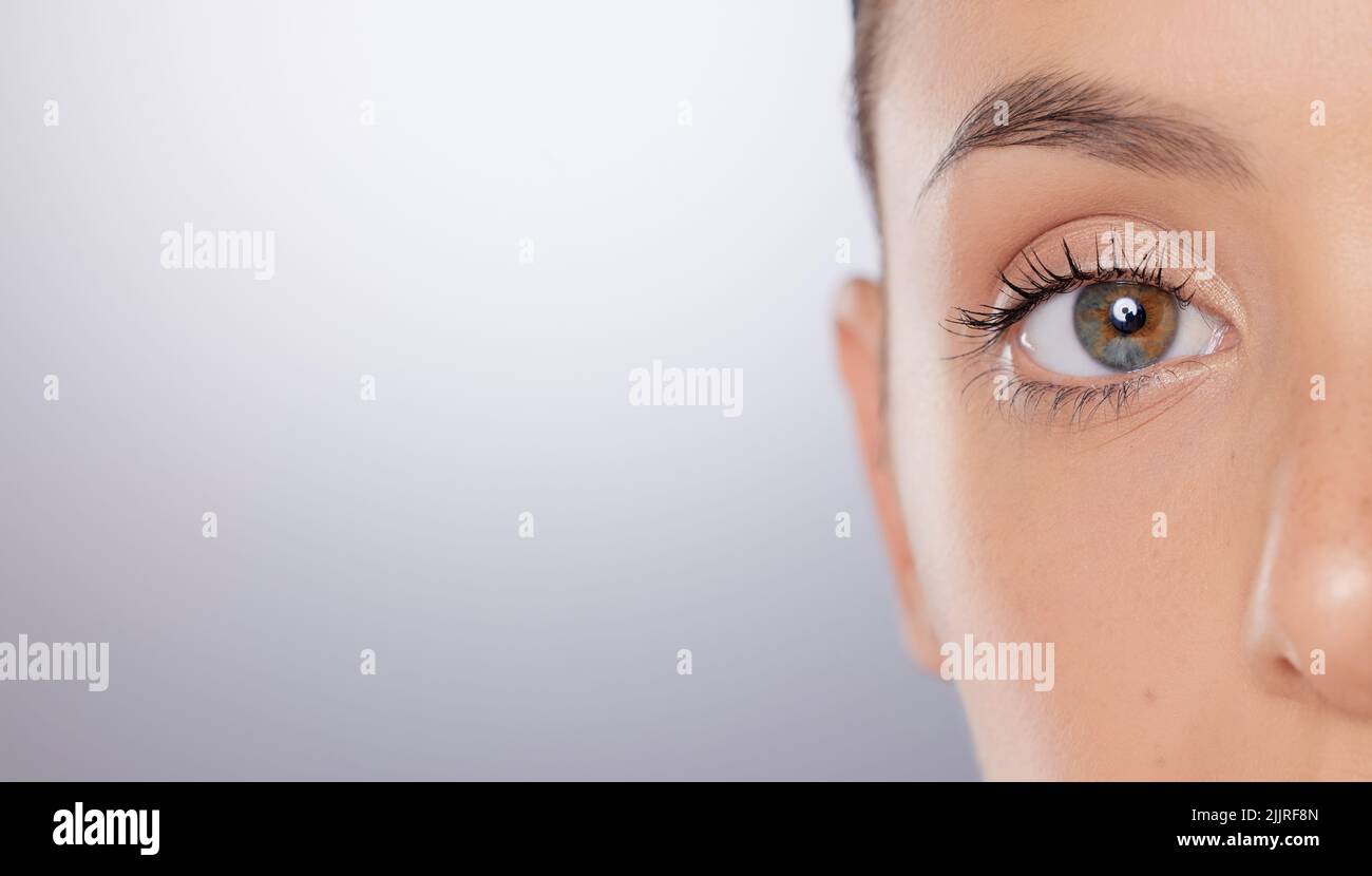 Mi piacciono le cose semplici nella vita. Primo piano di un giovane donna occhi su uno sfondo grigio. Foto Stock