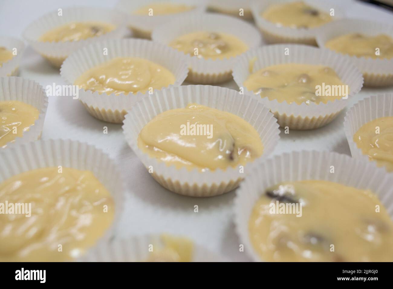Casse di carta riempite di pasta per muffin Foto Stock